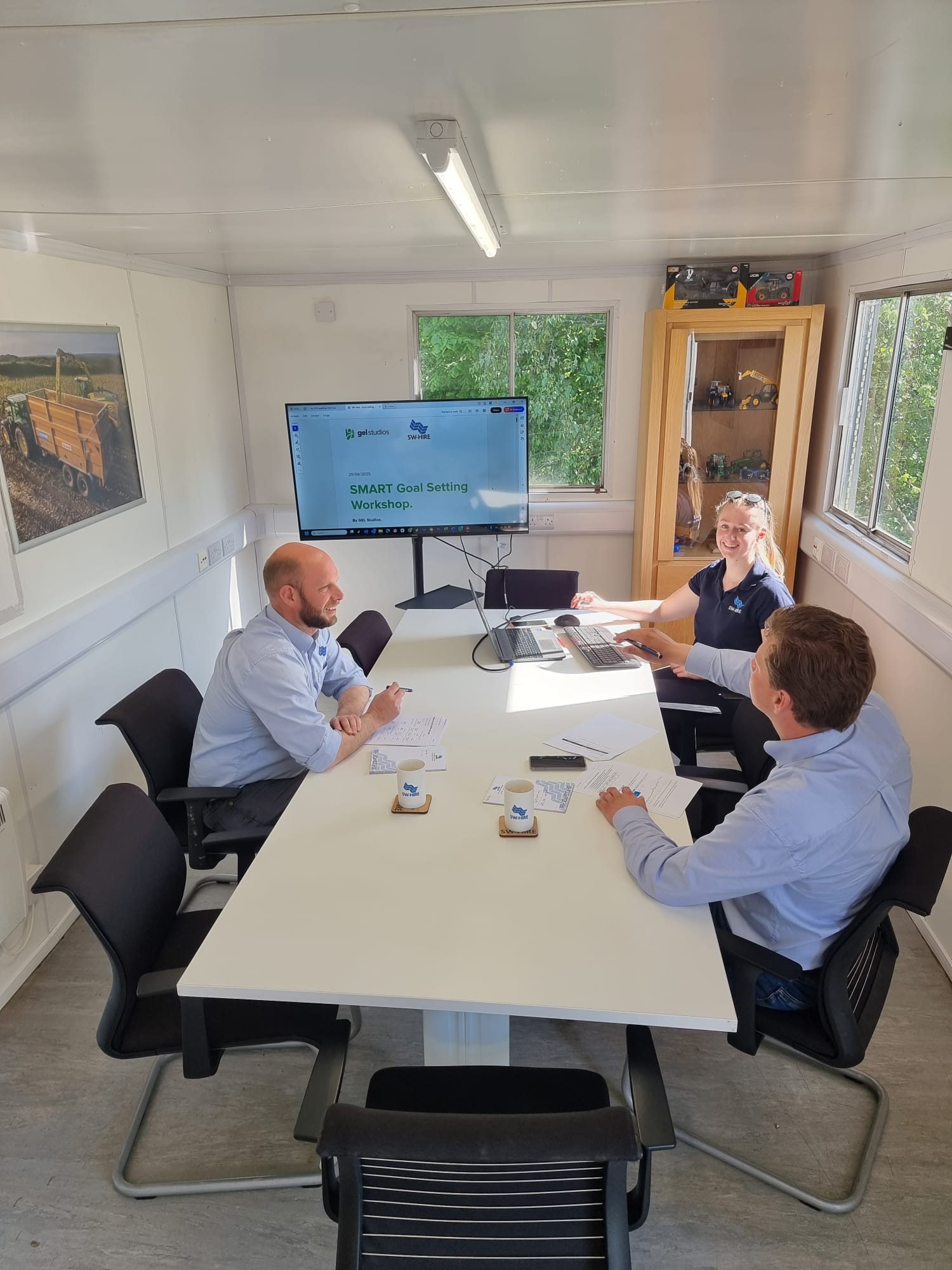 Managing Director Simon Williams, Hire Manager Jonny Taylor and Marketing Coordinator Mae Brown sat around a white table in a meeting room
